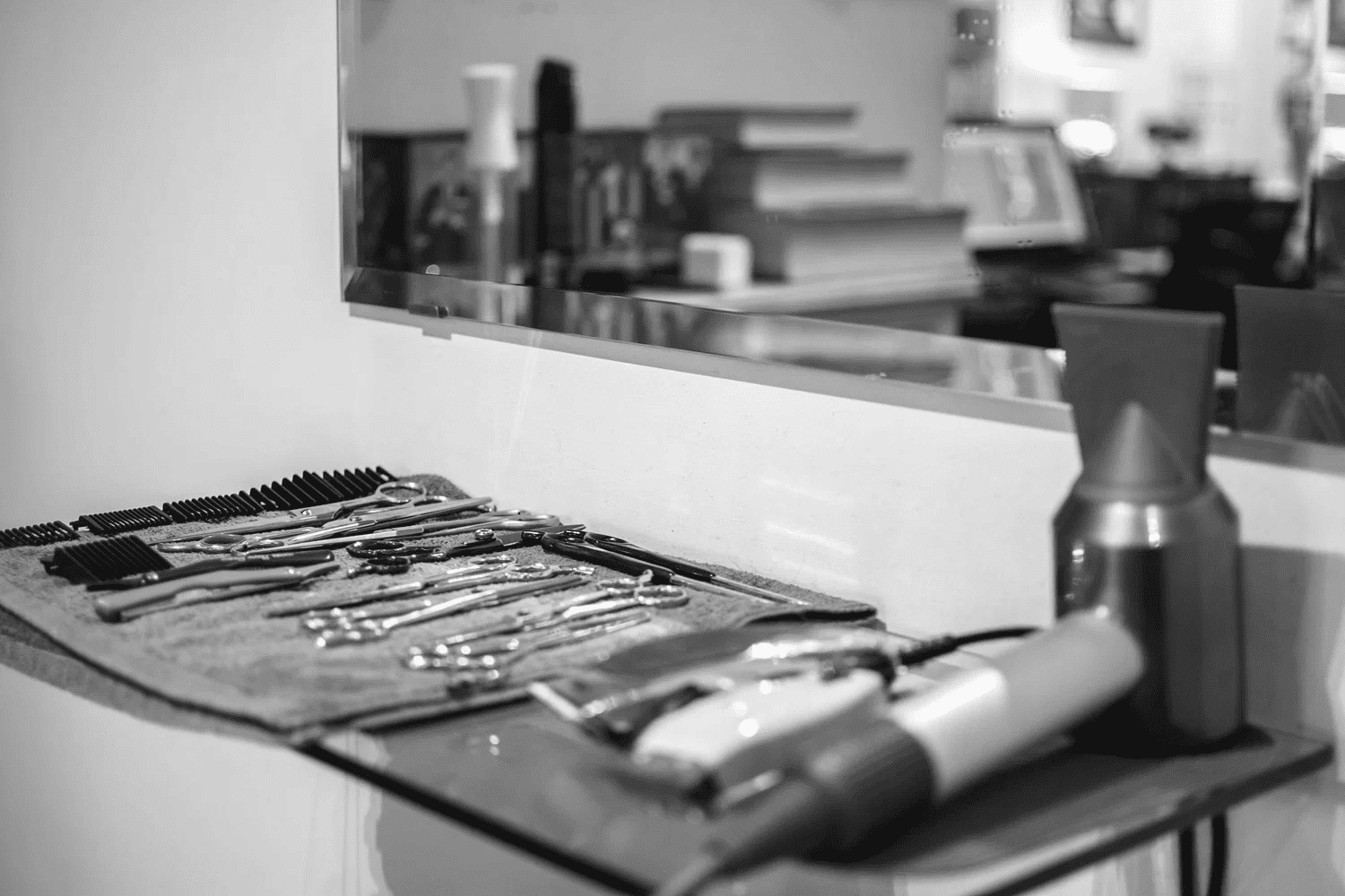 Hair salon tools laid out on a counter with a mirror in the background.